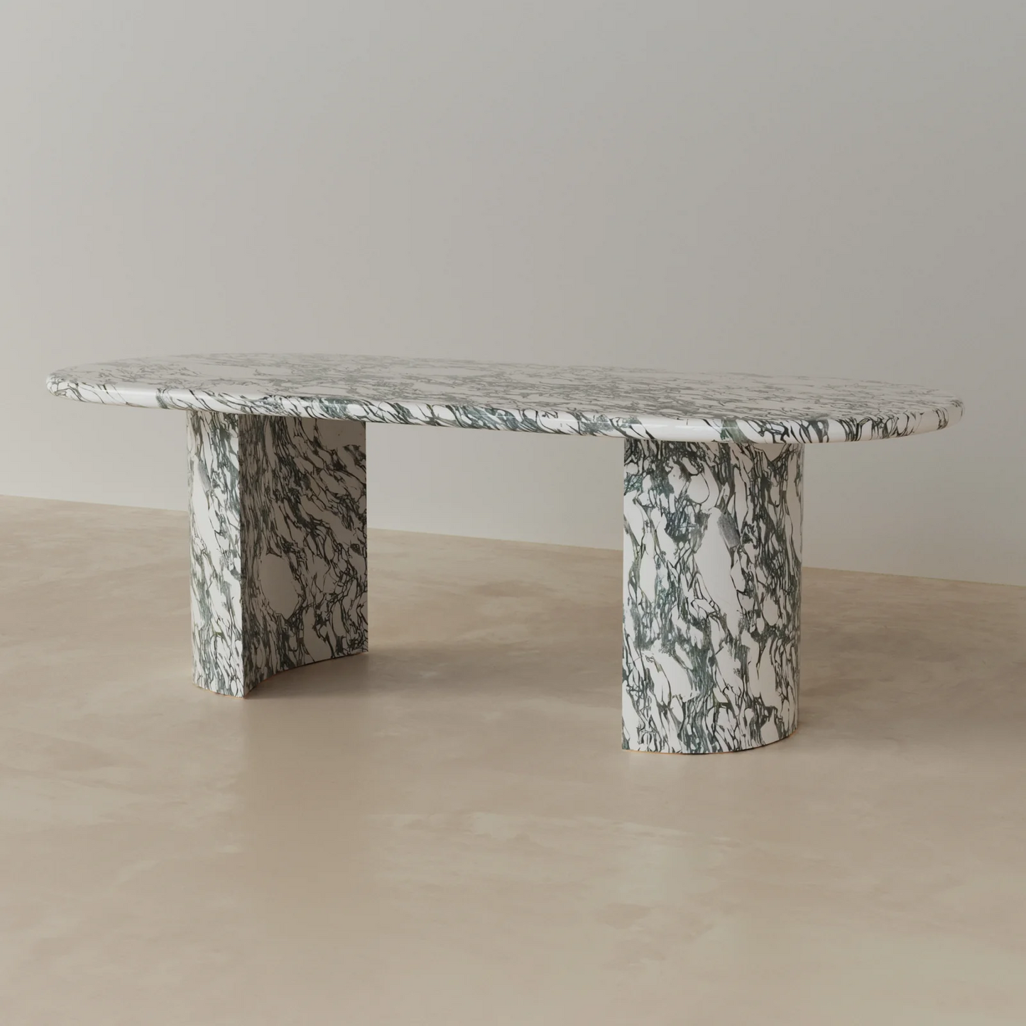 Side view of Anzio oval dining table in green marble with sculptural stone pedestal base