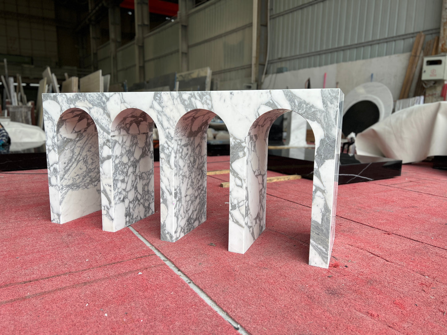 Arabescato marble Arca console table with sculptural arches in stone workshop