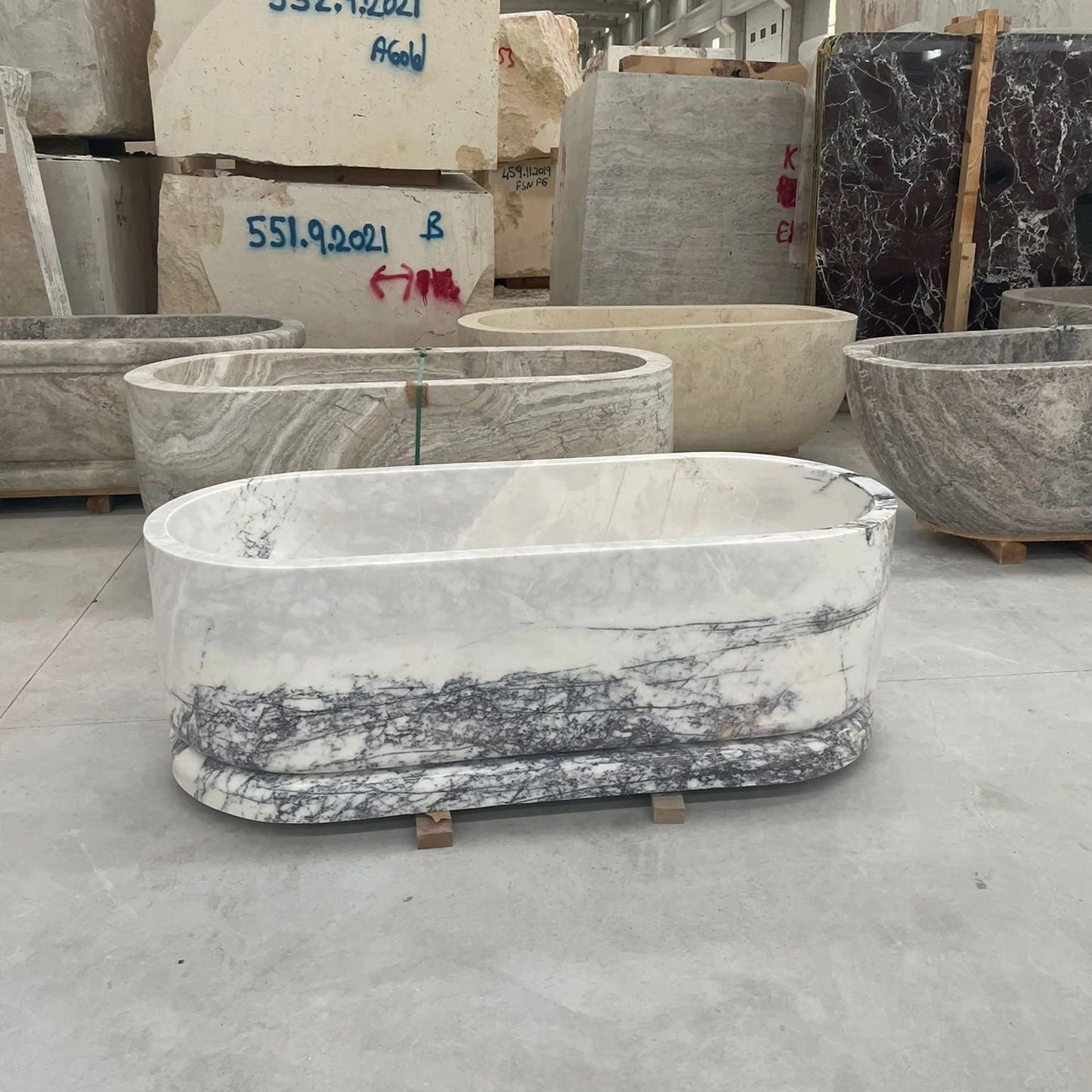 Calacatta marble freestanding bathtub in stone workshop by Eden Stone Designs