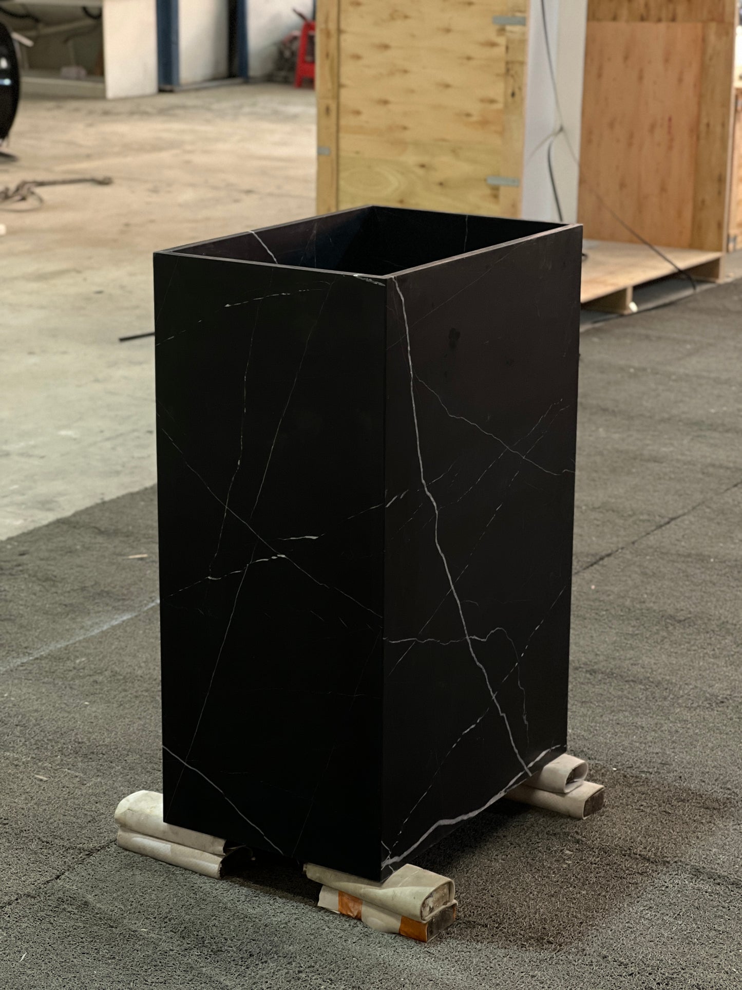 Freestanding Genoa marble vanity in black natural stone block with raw finish in workshop setting