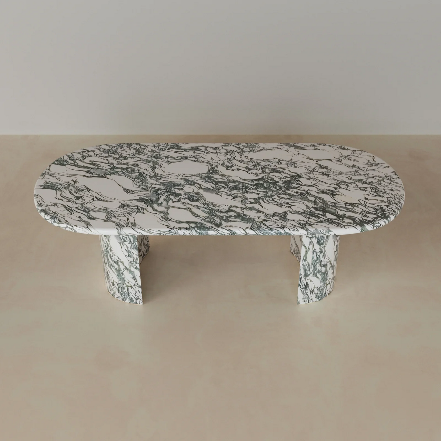 Anzio oval dining table in green marble with sculptural stone base and bold natural veining
