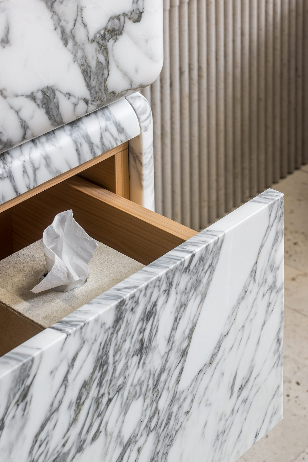 Marble vanity drawer detail with natural wood interior and soft close storage