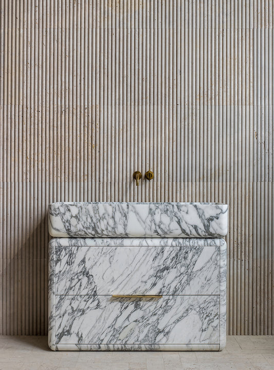 Luxury marble bathroom vanity with bold veining and fluted wall background in modern interior