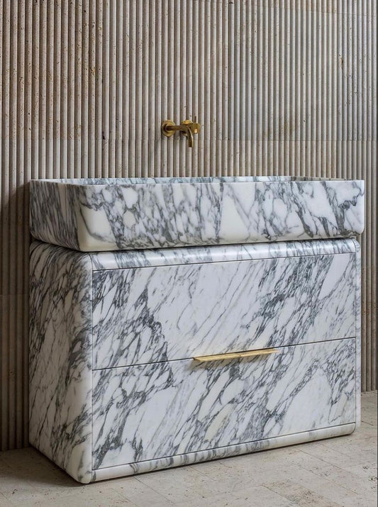 Modern marble bathroom vanity with bold veining and brass handle detail