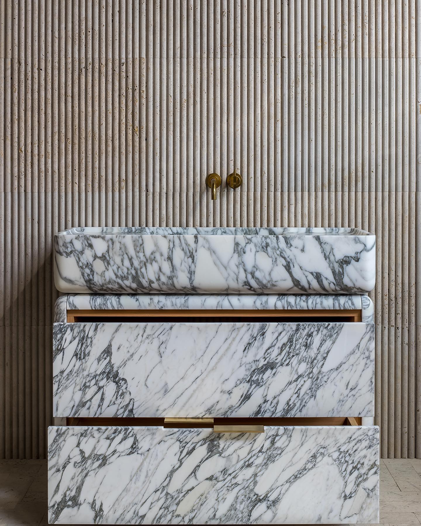 Luxury marble bathroom vanity with open drawer showing storage and natural wood interior