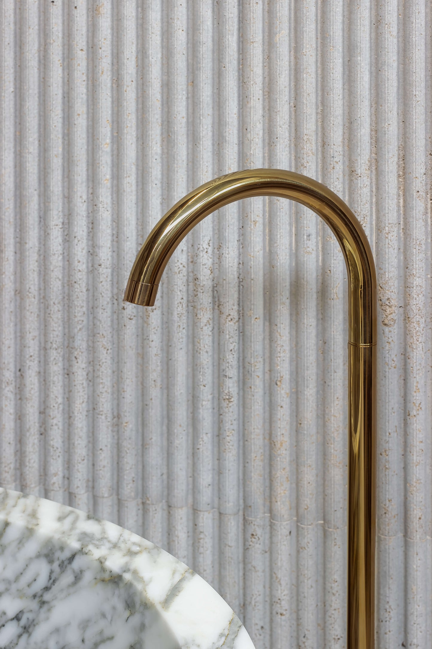 Brass bathtub faucet with Calacatta marble bathtub by Eden Stone Designs