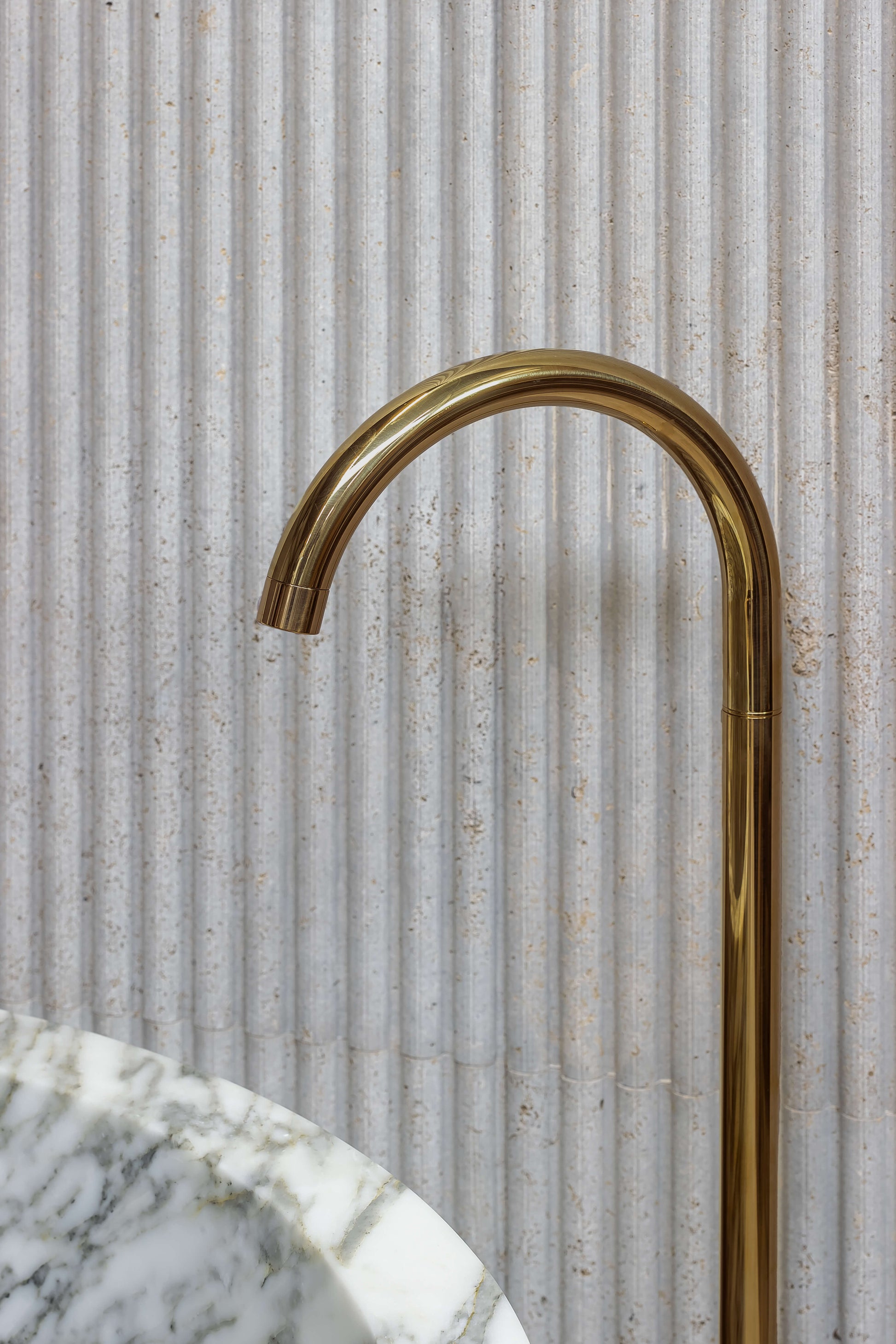 Brass bathtub faucet with Calacatta marble bathtub by Eden Stone Designs