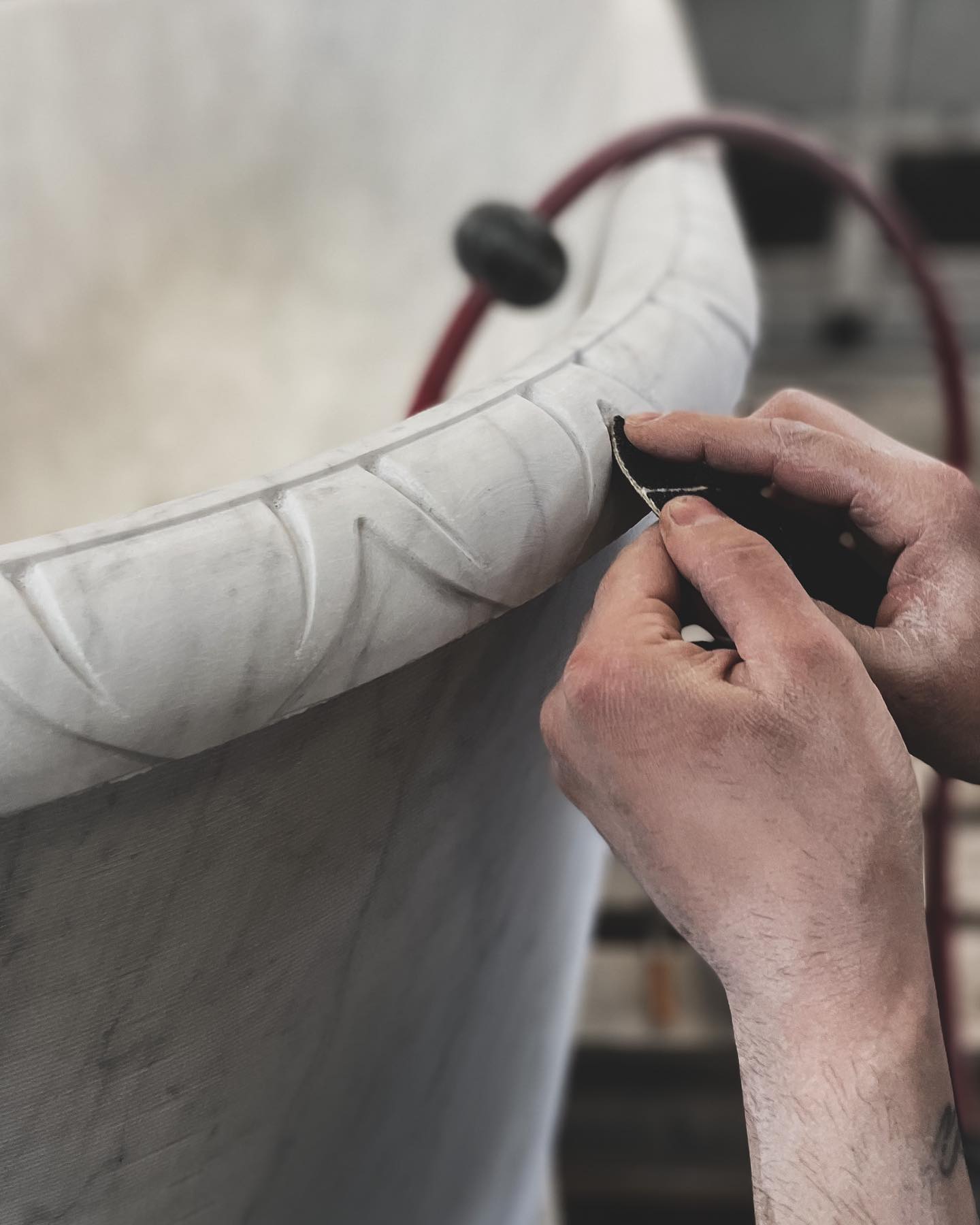 Stone artisan handcrafting a marble bathtub edge at Eden Stone Designs