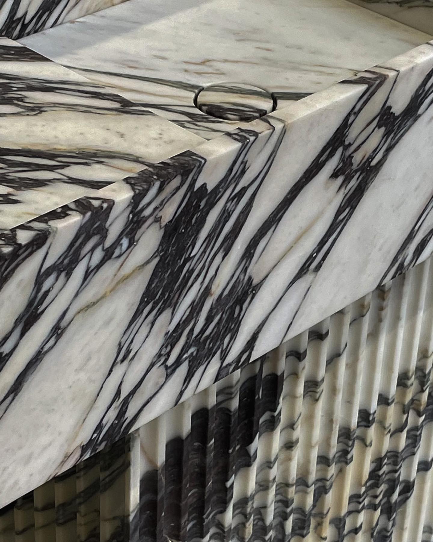 Florence marble vanity detail showing continuous veining and integrated drain in natural stone basin