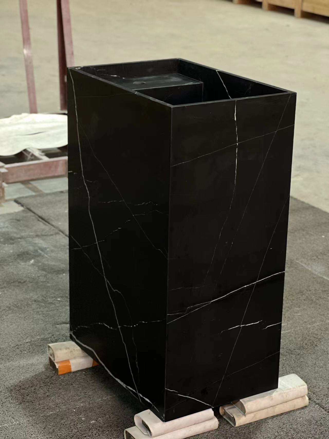 Freestanding Genoa marble vanity in black natural stone showing refined monolithic form in workshop