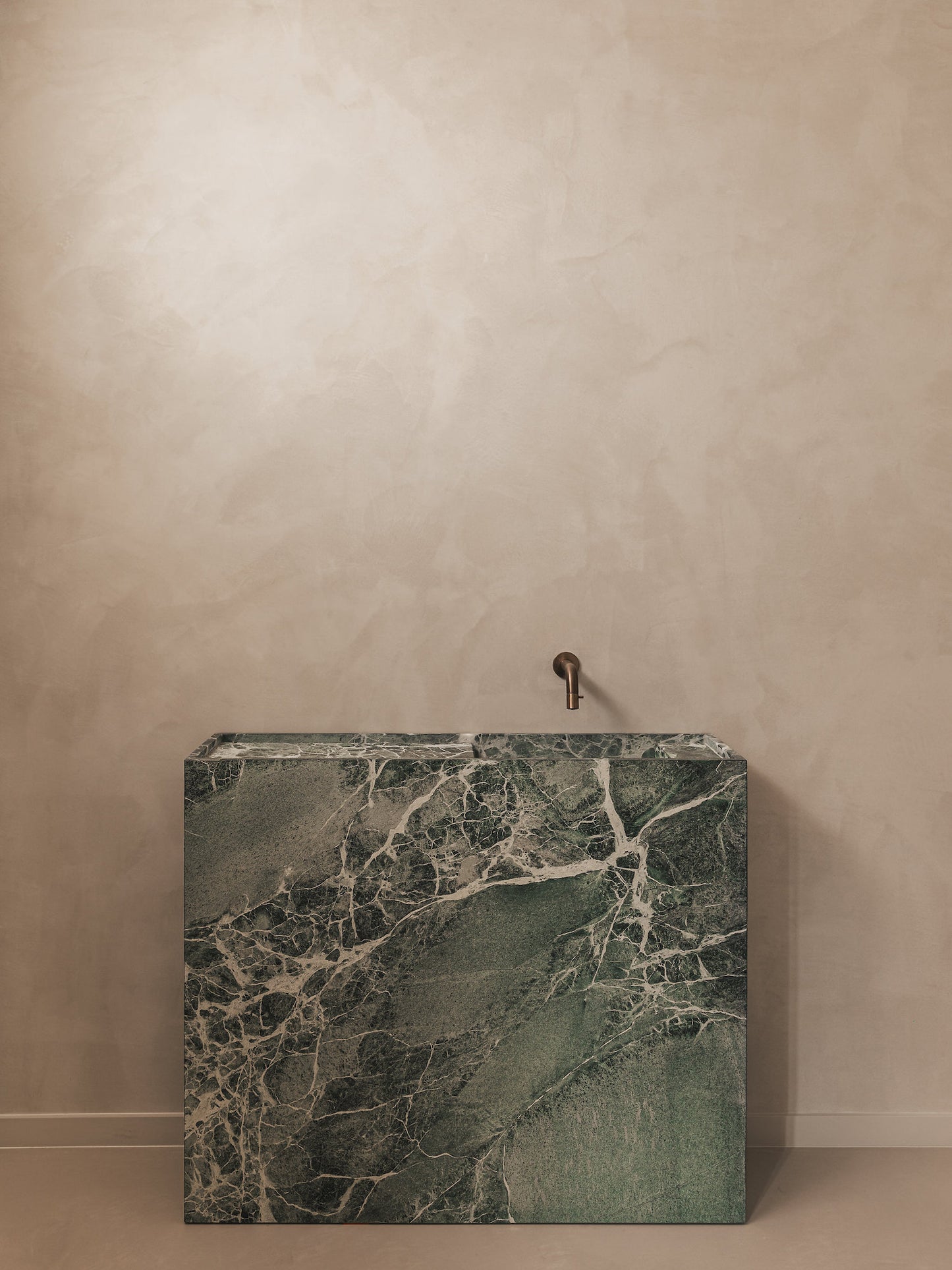 Genoa marble vanity in green natural stone with white veining in a minimalist bathroom setting