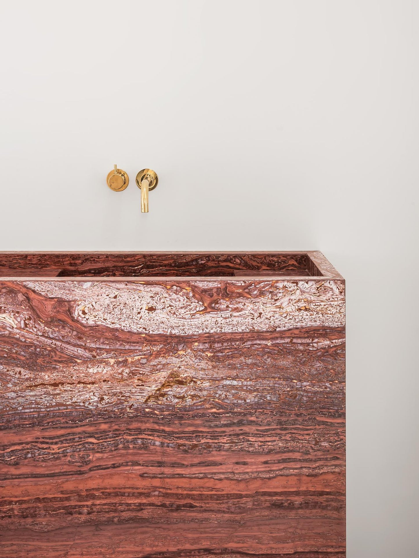Front detail of Genoa marble vanity showing red natural stone with layered horizontal veining
