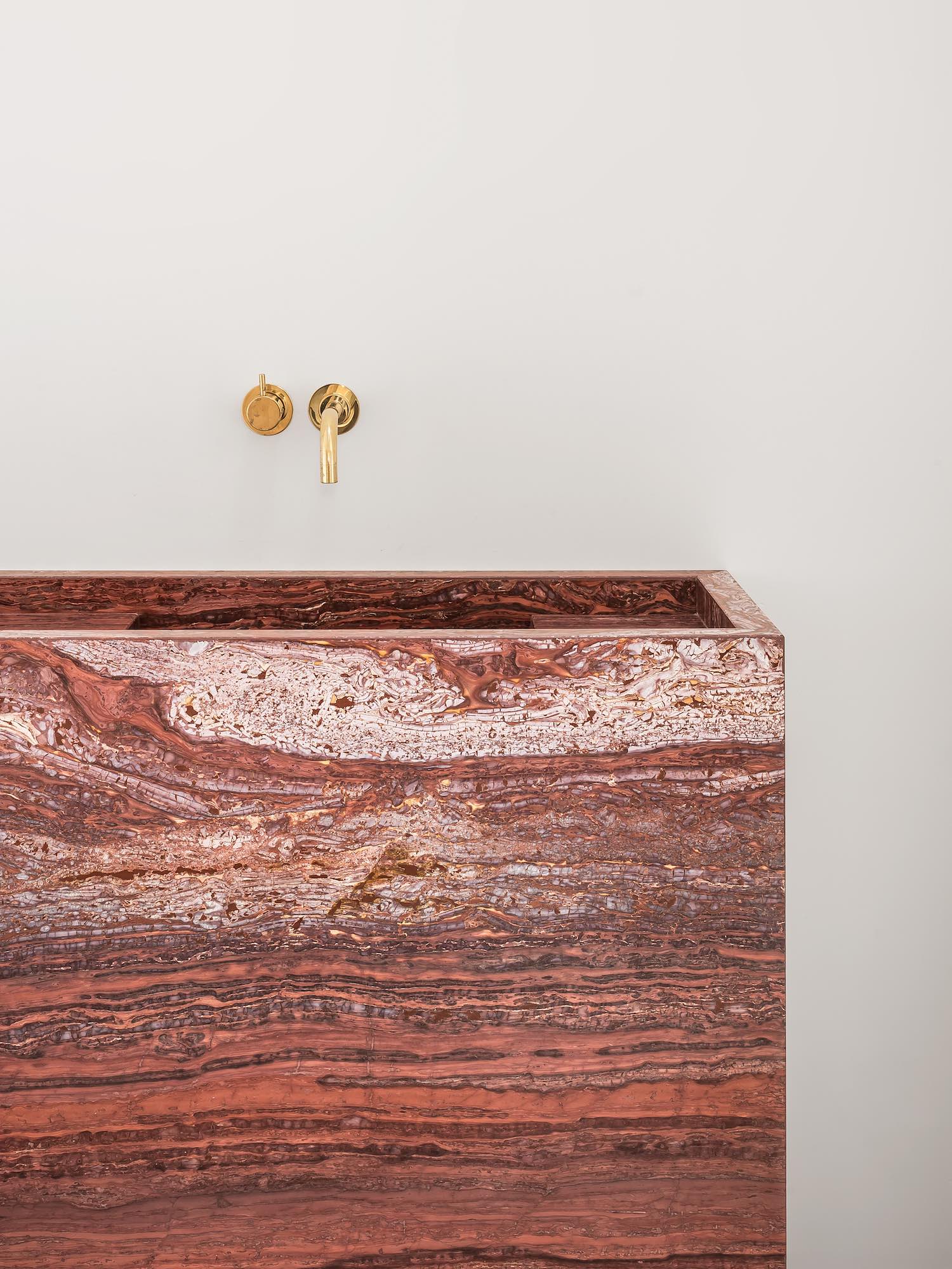 Front detail of Genoa marble vanity showing red natural stone with layered horizontal veining