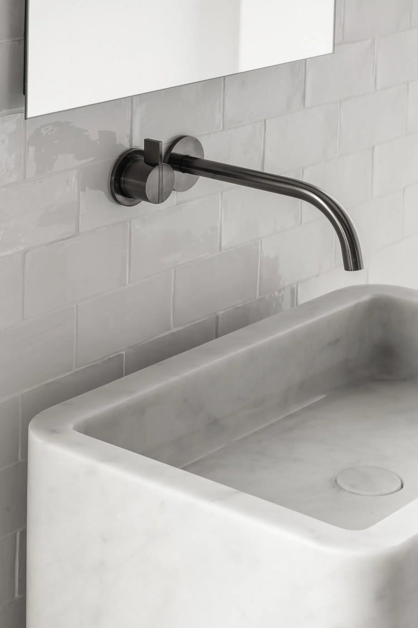 Close up of Genoa marble vanity in white natural stone with integrated basin and wall mounted faucet