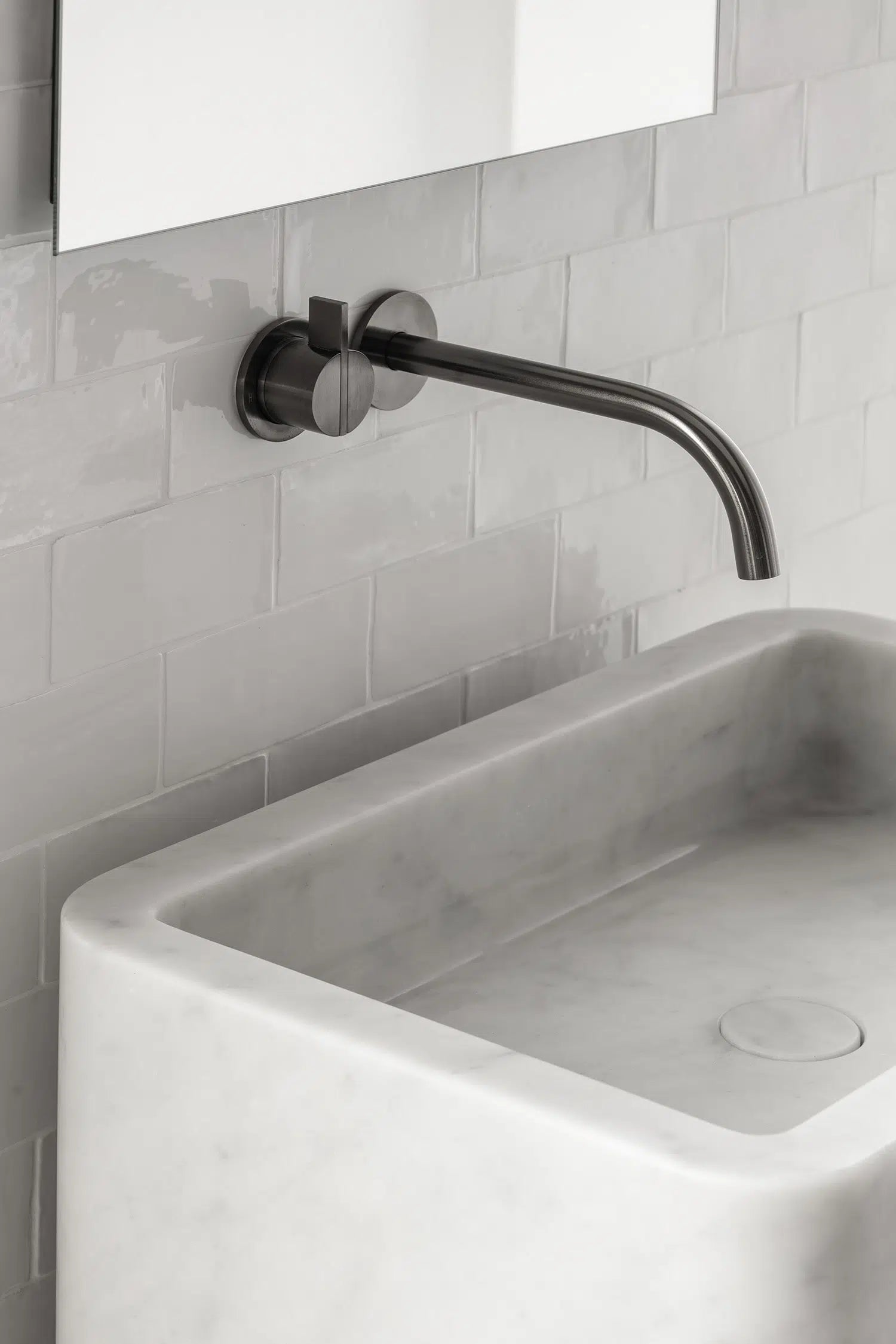 Close up of Genoa marble vanity in white natural stone with integrated basin and wall mounted faucet