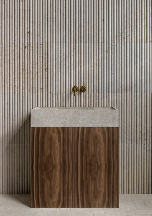 Teak wood bathroom vanity with natural marble sink and fluted stone wall background