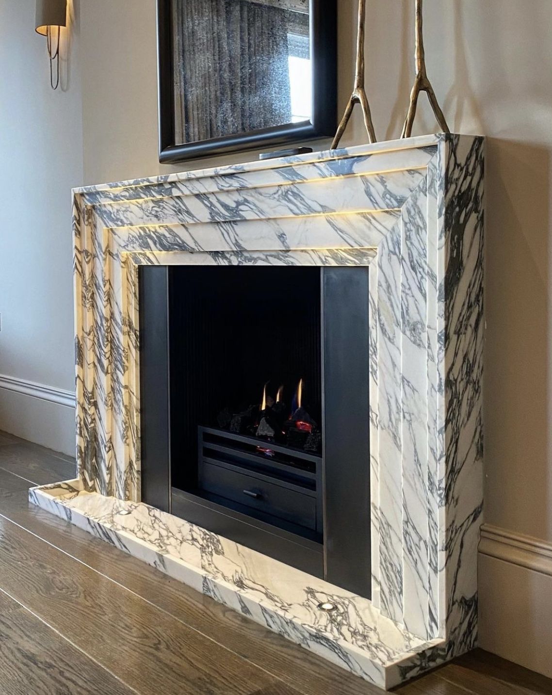 Tivoli Carrara marble fireplace surround in luxury interior with modern gas fire