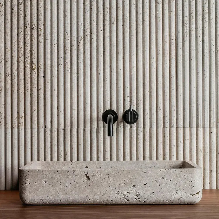 Milan travertine stone sink with fluted wall and black faucet minimal luxury bathroom design Eden Stone Designs