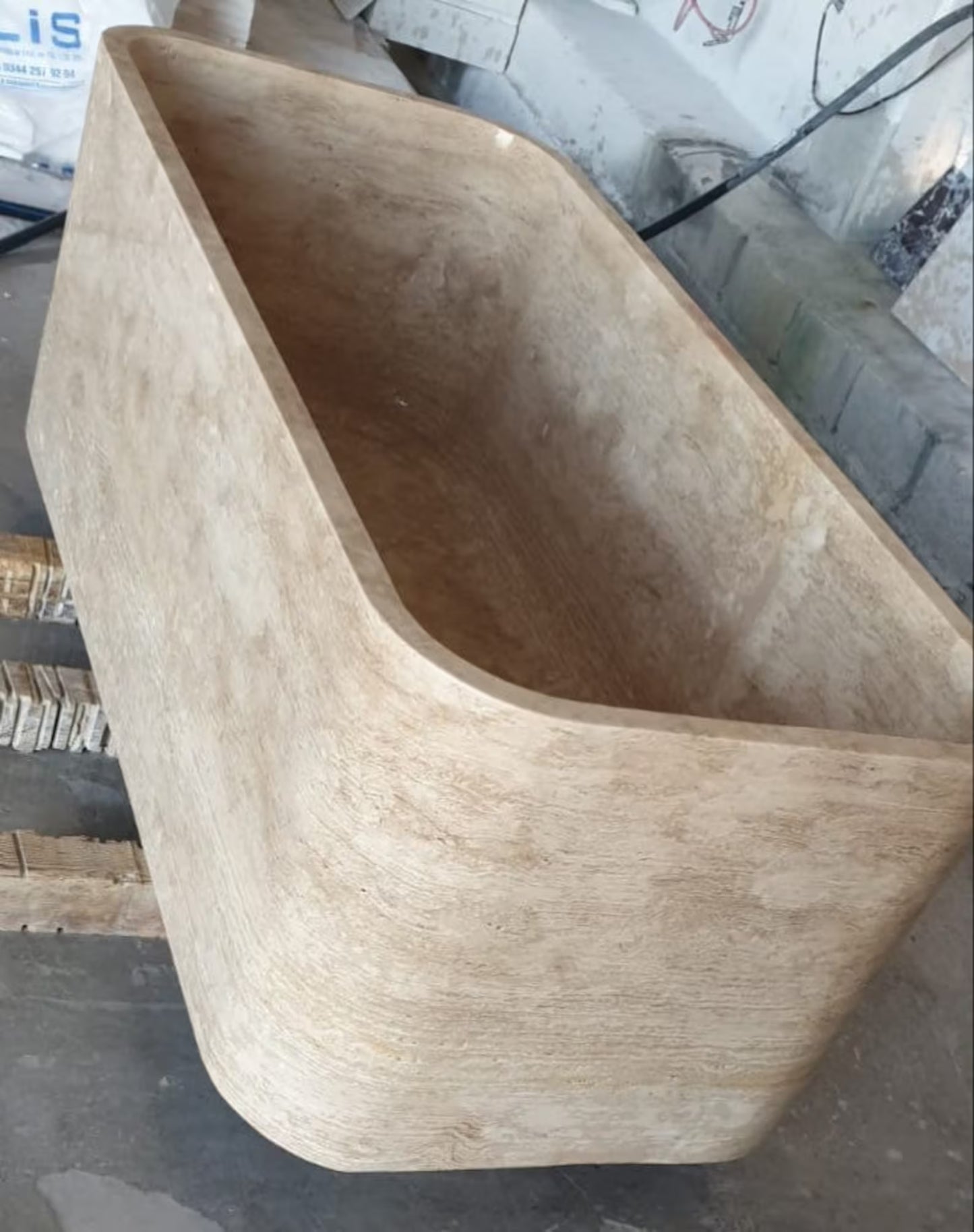 Mirlo travertine stone bathtub carved from a single block of natural stone shown from diagonal angle