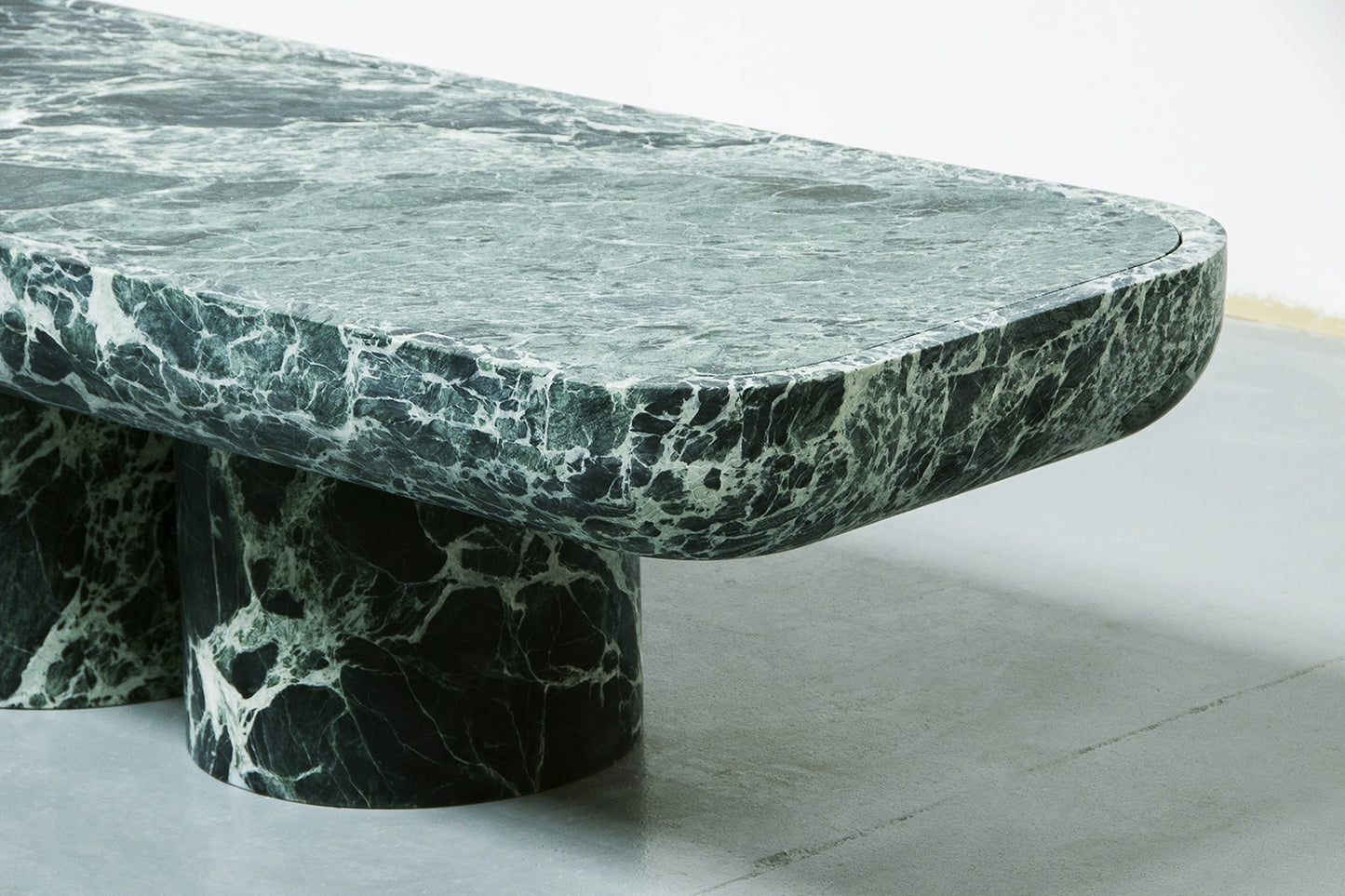 Corner detail of Novara green marble coffee table with cylindrical base by Eden Stone Designs