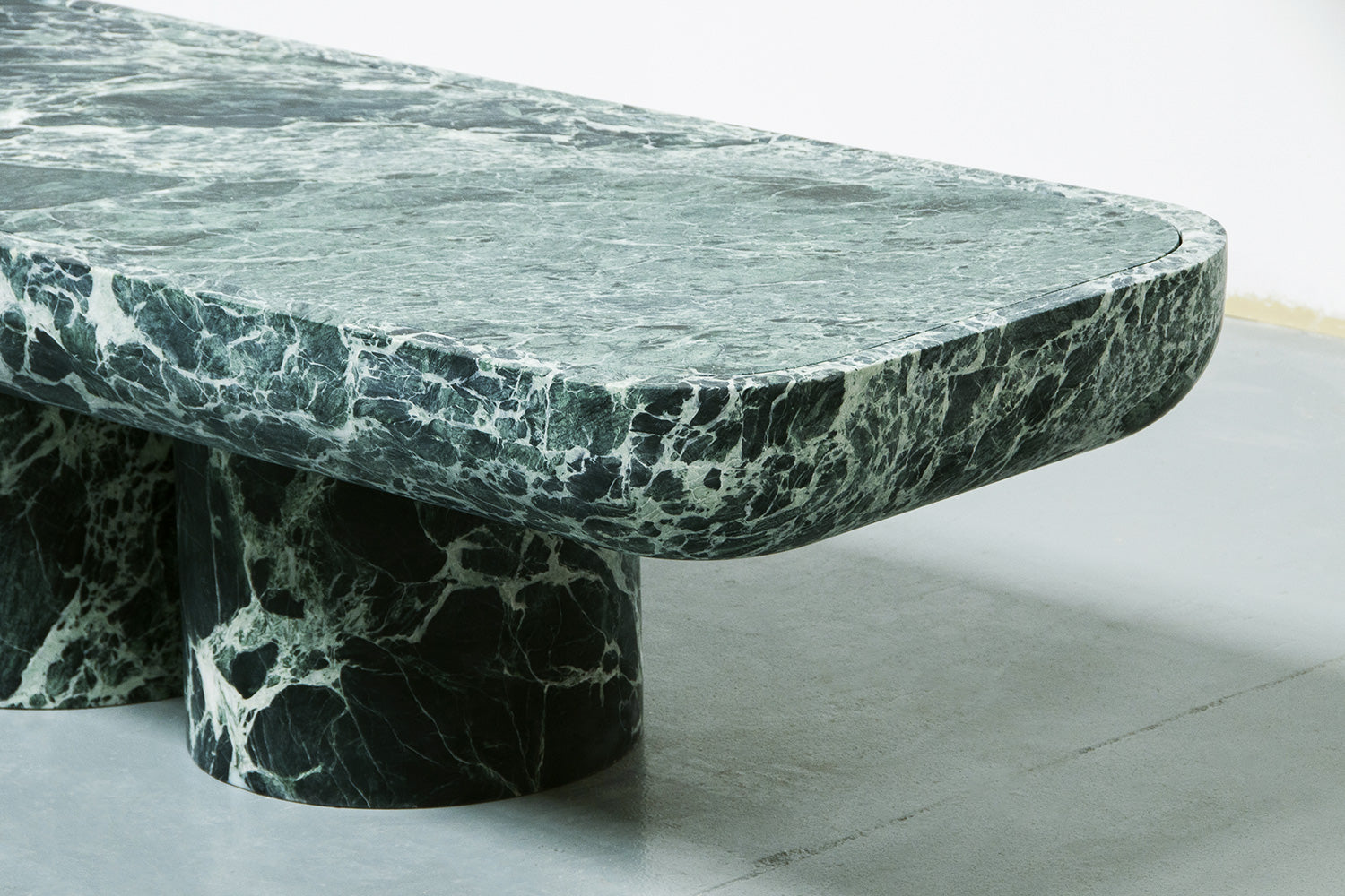 Corner detail of Novara green marble coffee table with cylindrical base by Eden Stone Designs