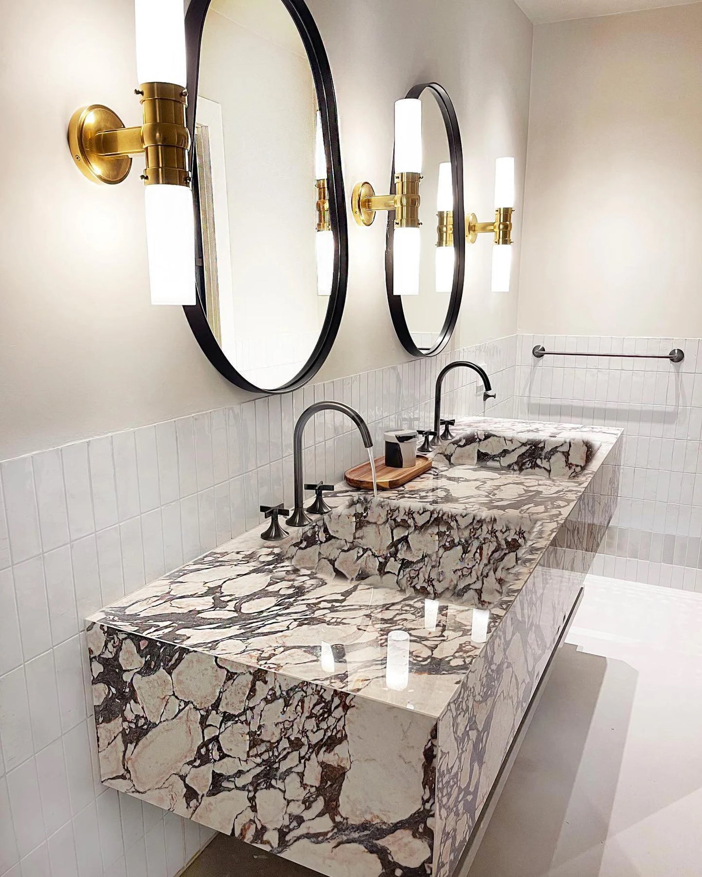 Toscana marble sink double vanity with integrated basins, round mirrors and brass wall lights in modern bathroom