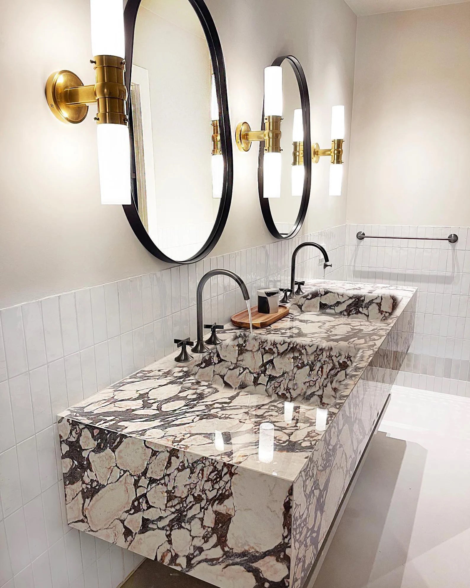 Toscana marble sink double vanity with integrated basins, round mirrors and brass wall lights in modern bathroom