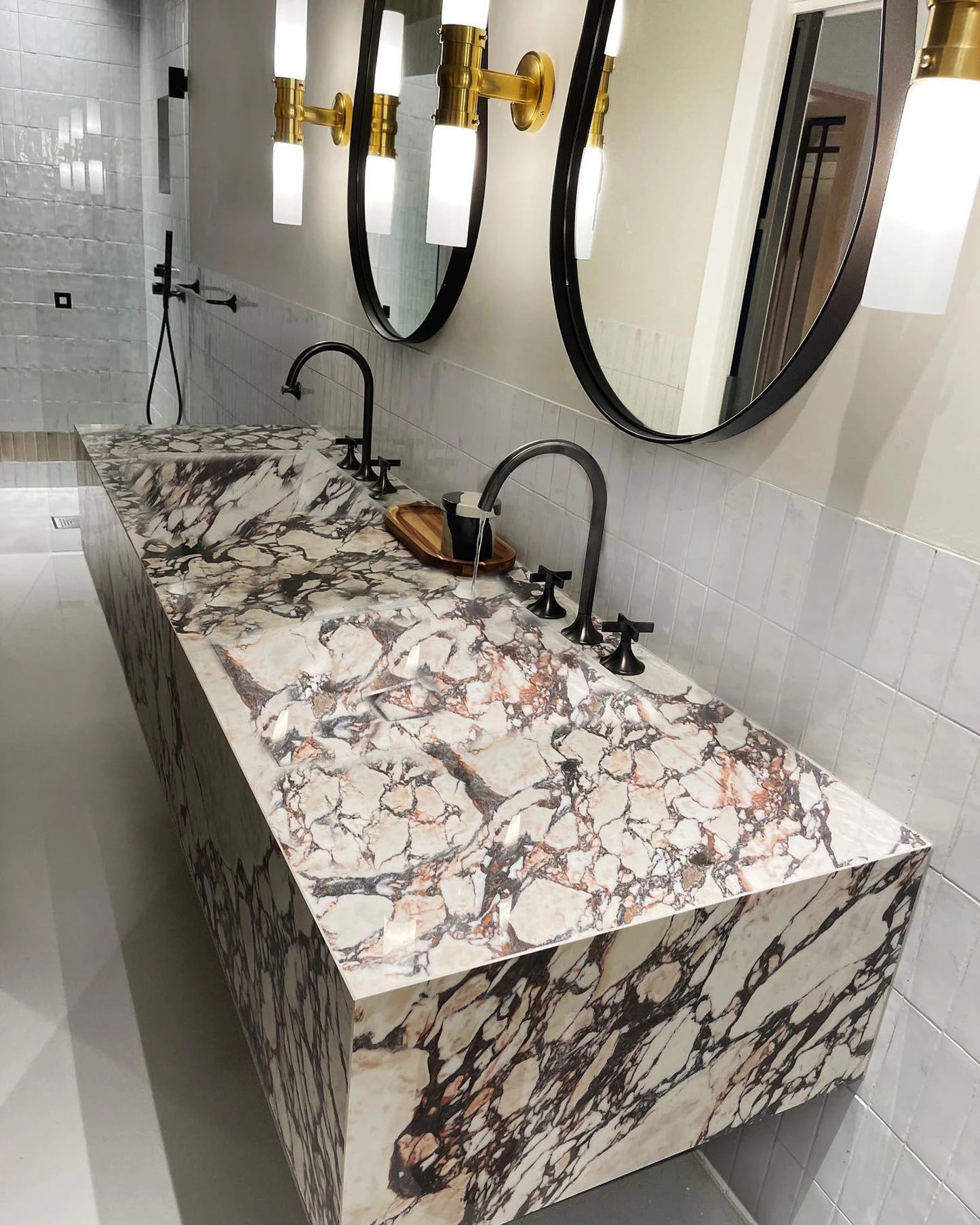 Toscana marble sink double vanity with integrated basins and modern black faucets in contemporary bathroom