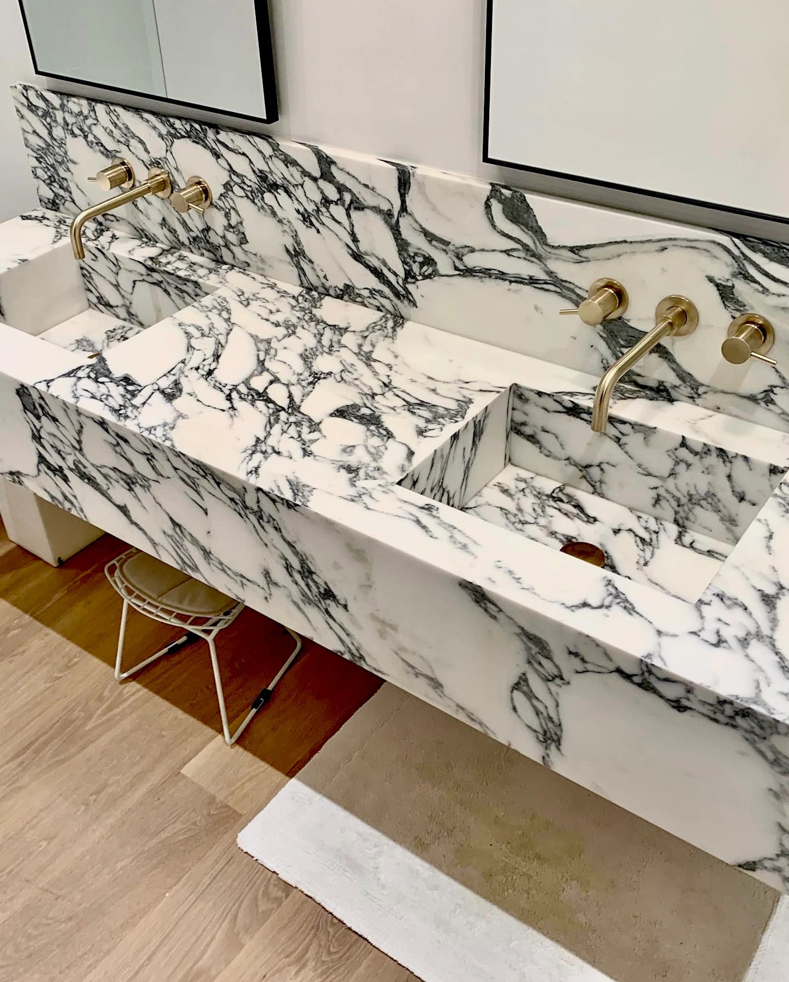 Toscana marble sink double vanity installed in real bathroom with wall-mounted brass faucets and natural stone veining