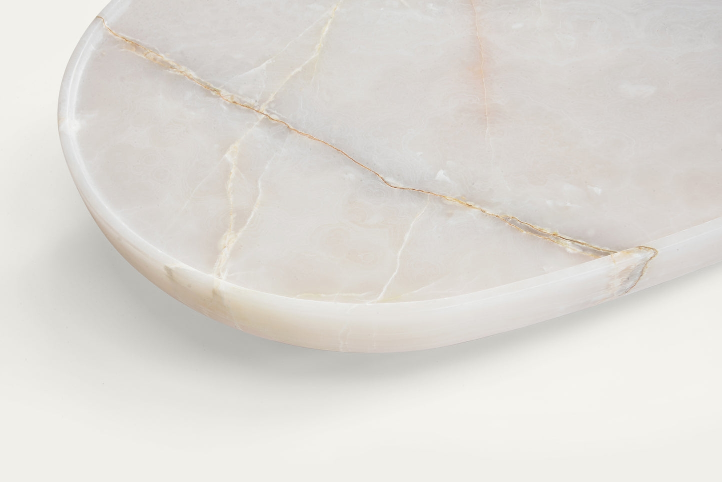 Detail of Trento onyx marble coffee table by Eden Stone Designs showing natural stone veining and polished edge