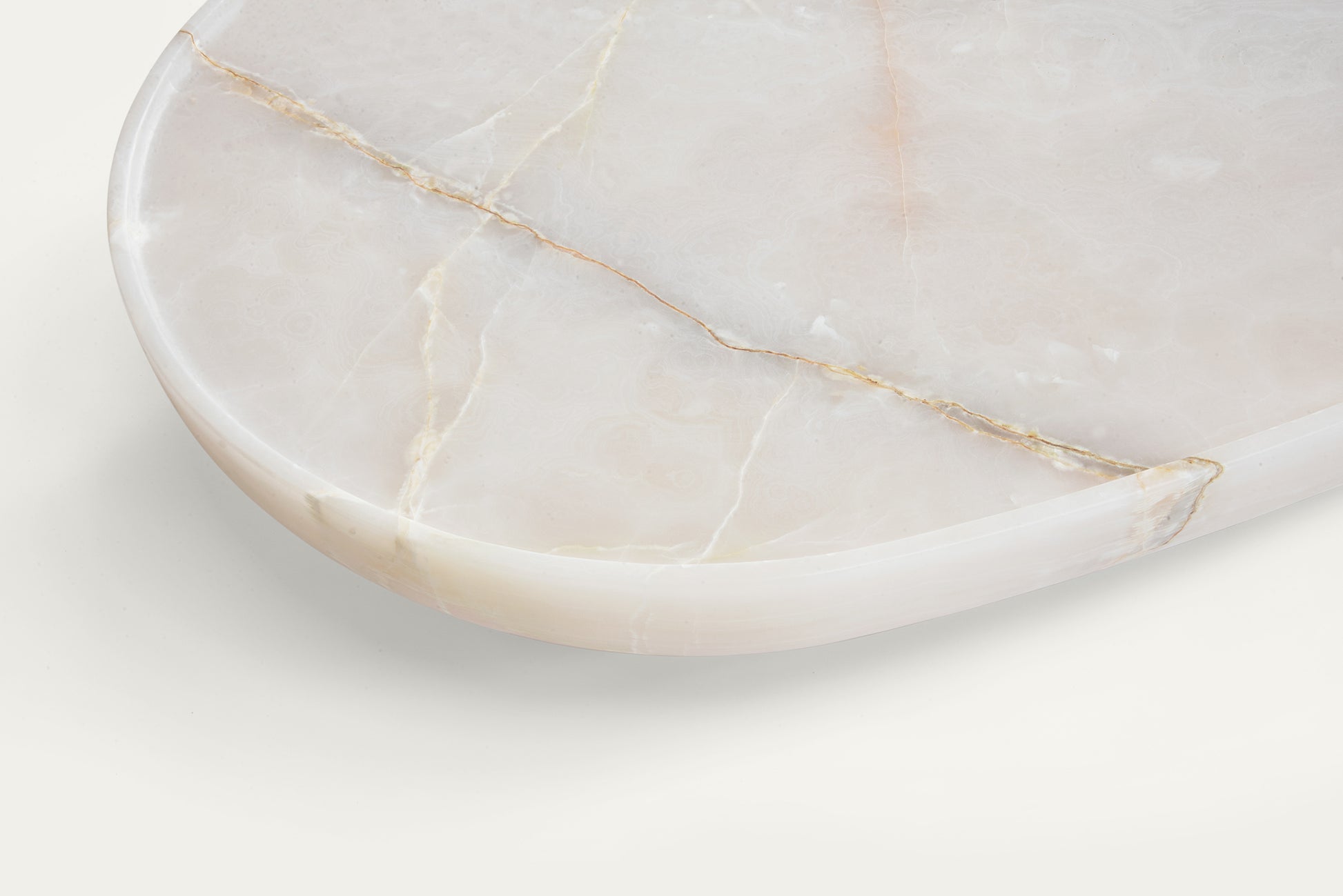 Detail of Trento onyx marble coffee table by Eden Stone Designs showing natural stone veining and polished edge