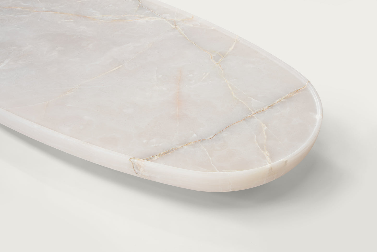 Trento onyx marble coffee table top detail by Eden Stone Designs showing natural stone veining and polished oval edge