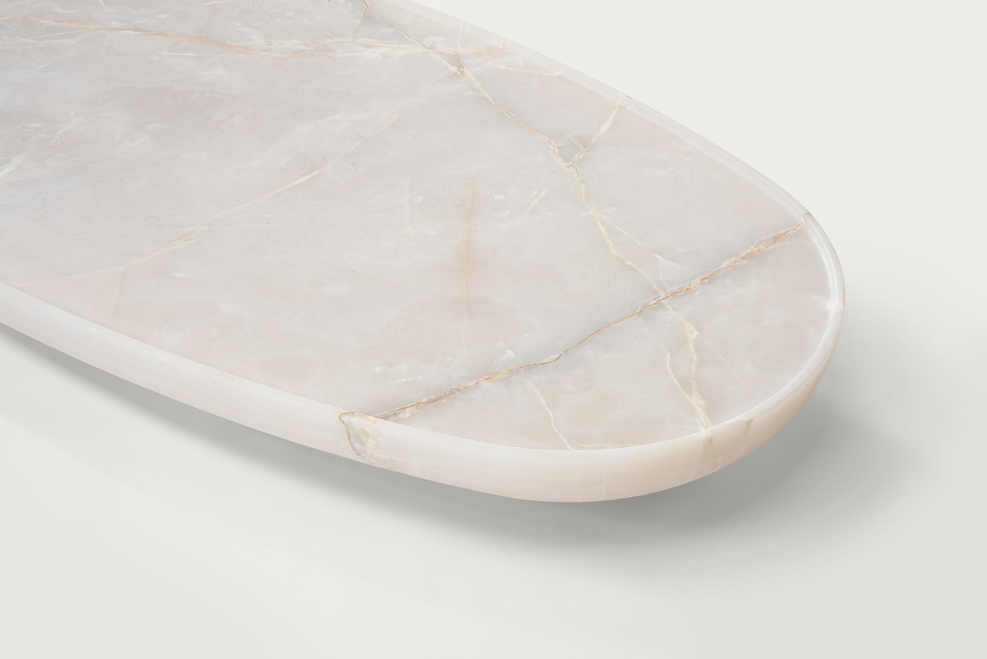 Trento onyx marble coffee table top detail by Eden Stone Designs showing natural stone veining and polished oval edge