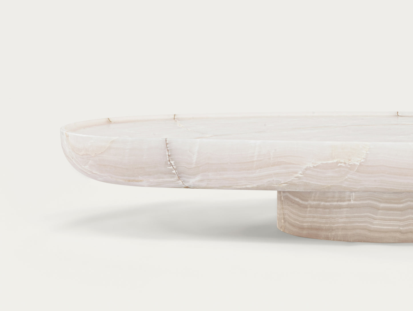 Trento oval onyx coffee table by Eden Stone Designs showing sculptural base and natural stone veining