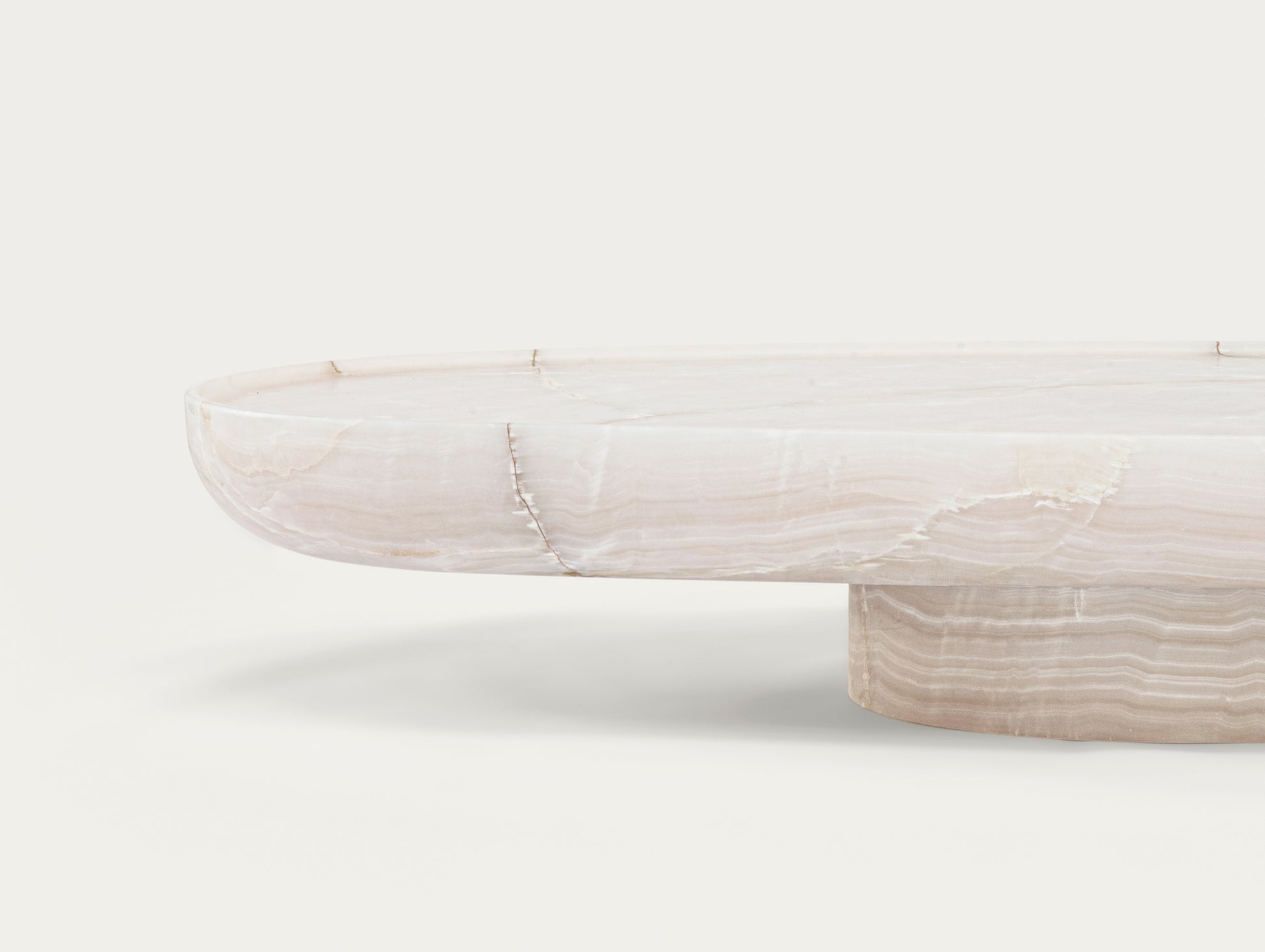 Trento oval onyx coffee table by Eden Stone Designs showing sculptural base and natural stone veining