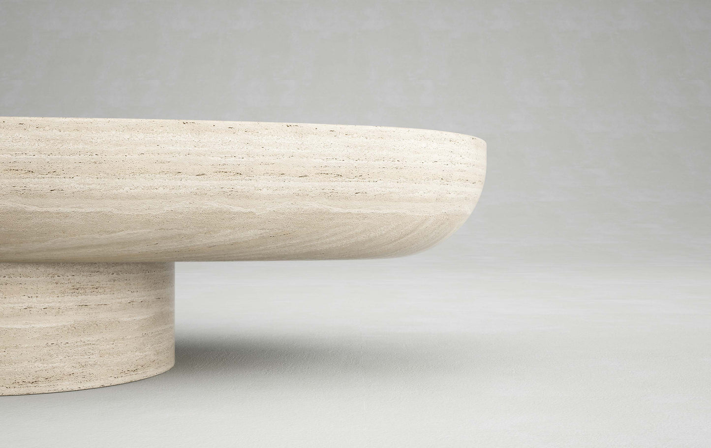 Edge detail of the Trento travertine oval coffee table by Eden Stone Designs highlighting natural stone texture and sculptural base
