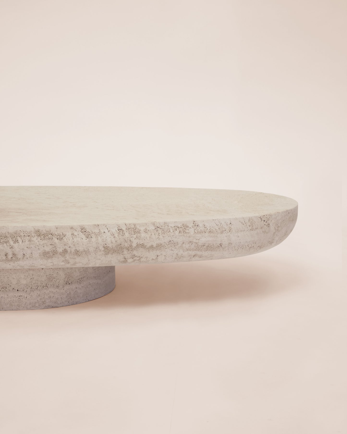 Trento travertine oval coffee table by Eden Stone Designs showcasing natural stone texture and sculptural pedestal base