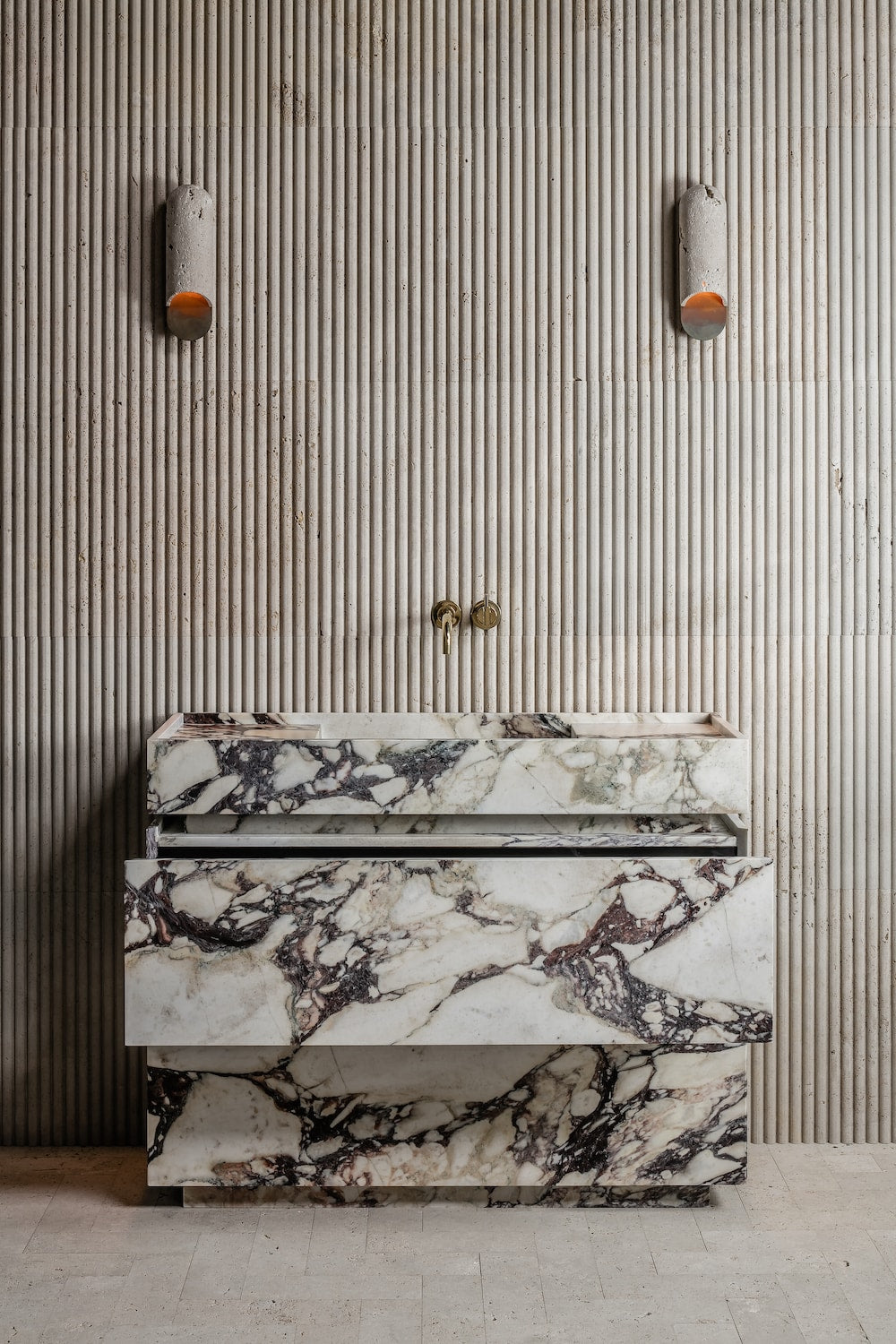 Venice marble vanity in Calacatta Viola natural stone with open drawer showing integrated storage in architectural bathroom