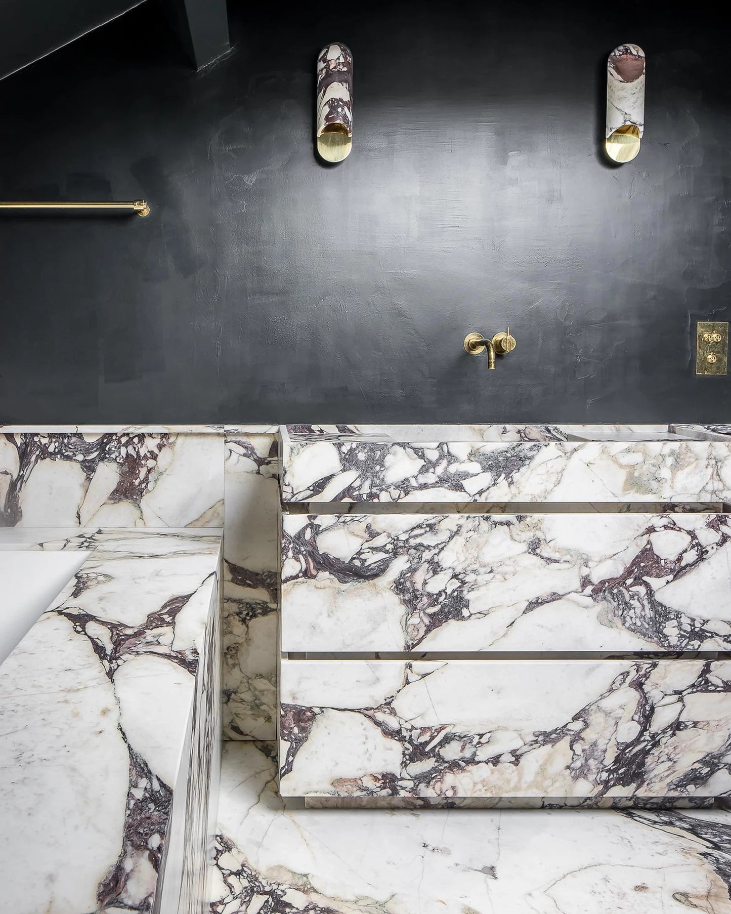 Venice marble vanity in Calacatta Viola natural stone integrated into a luxury bathroom with matching marble surfaces and brass fixtures