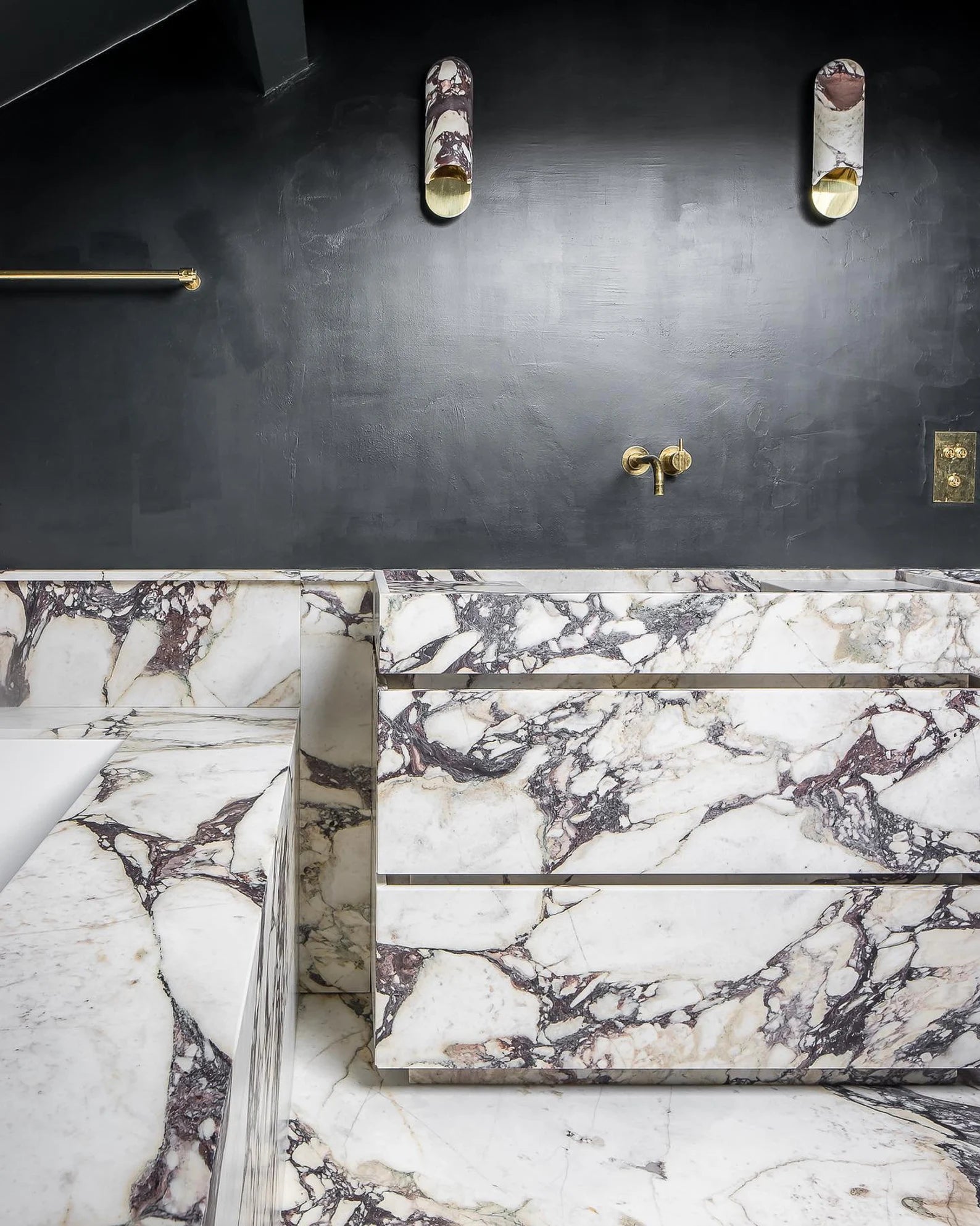 Venice marble vanity in Calacatta Viola natural stone integrated into a luxury bathroom with matching marble surfaces and brass fixtures