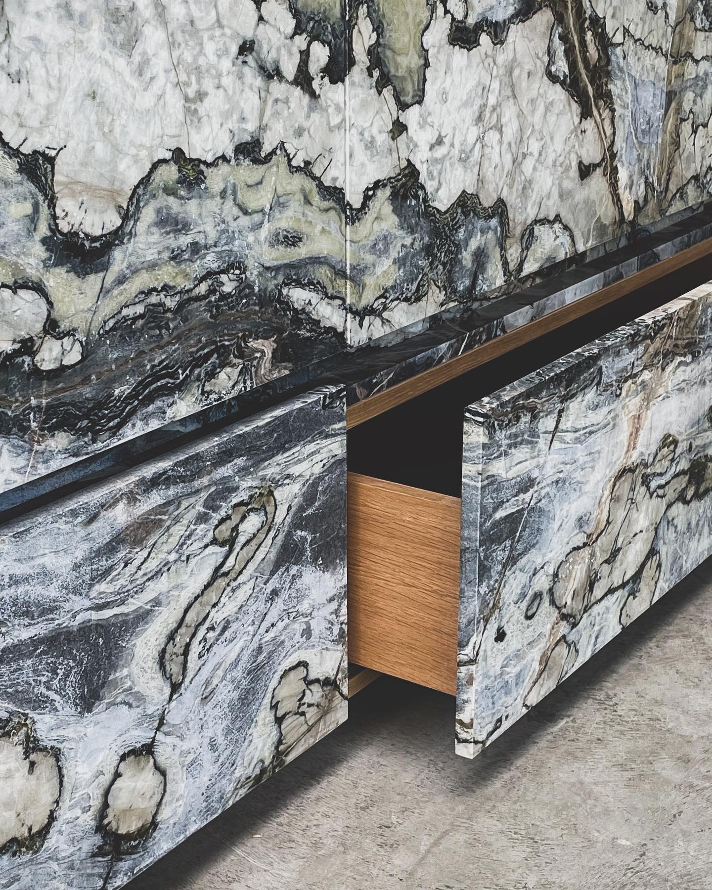 Luxury marble vanity with continuous veining across drawers and wooden interior craftsmanship detail